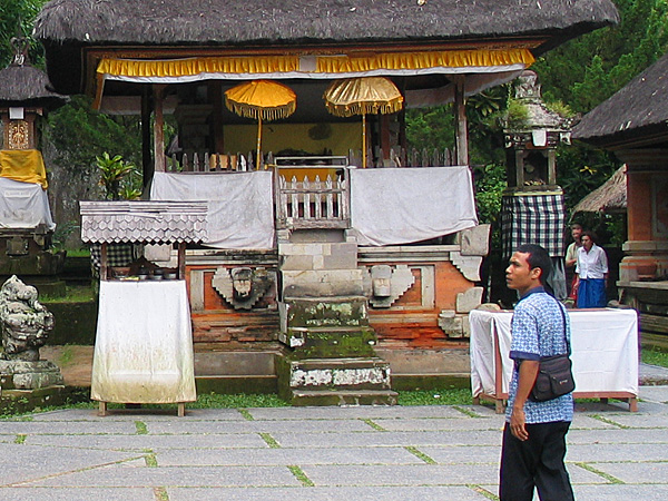 バリ島の寺院の境内で、日本語ガイドが旅行者を案内しているところ