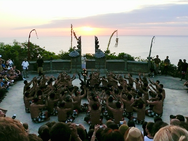 夕日の時間に舞台へ入り、輪になって座るケチャの踊り手たち